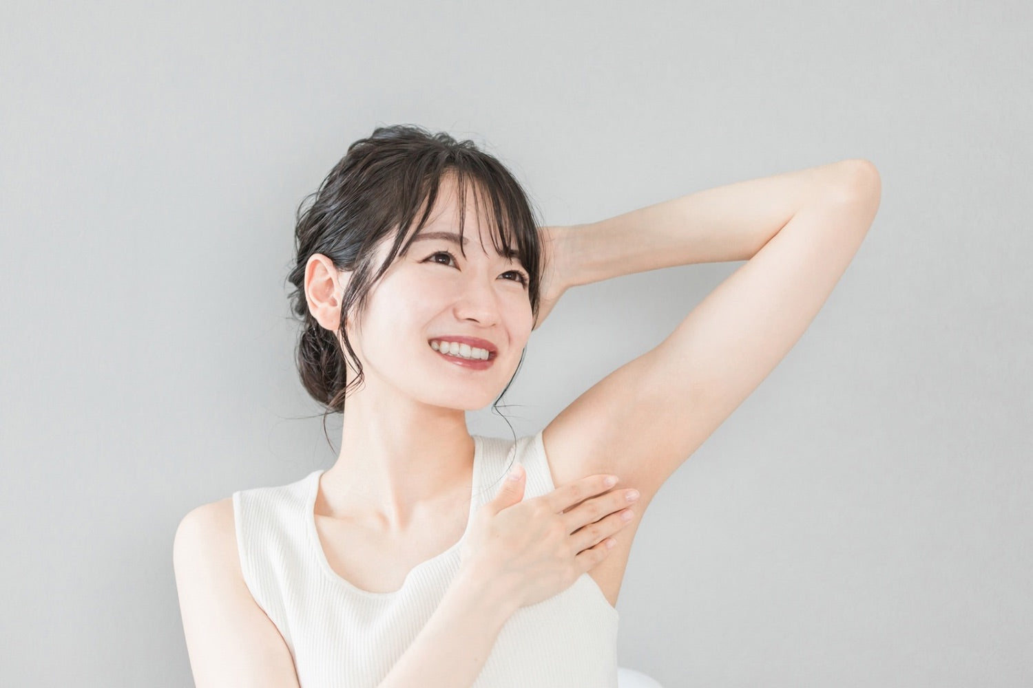Woman applying deodorant to her underarm