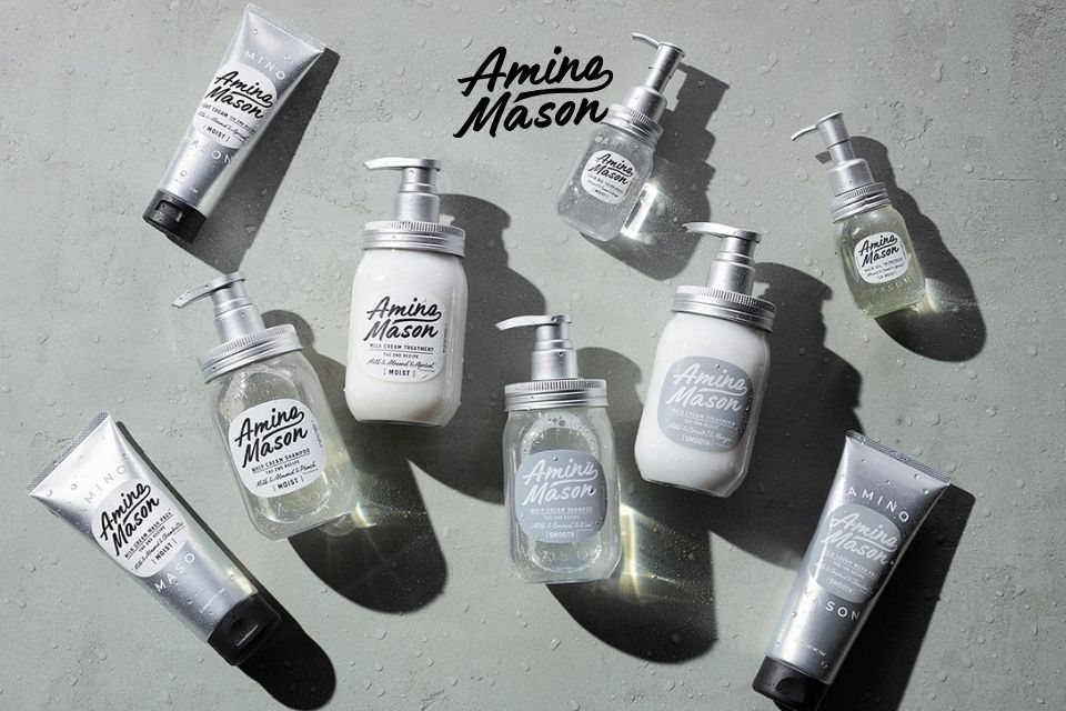 Amino Mason hair care products on a textured background. Featuring rich, creamy foam shampoo, treatment, and oil with super amino acids and milk-derived ingredients for deep nourishment and moisture, leaving hair manageable and beautiful.